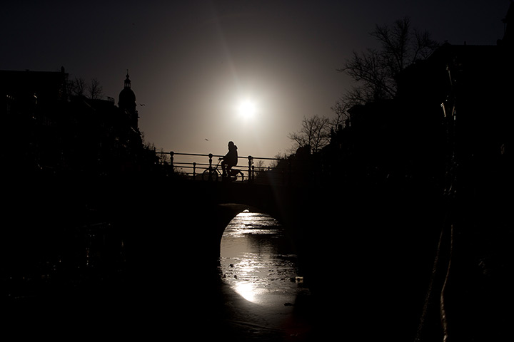 24 hours: A cyclist is silhouetted while crossing the Keizersgracht 