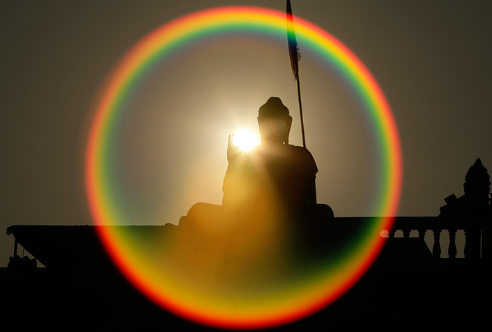 24 hours: A Buddha statue is silhouetted by the sun 