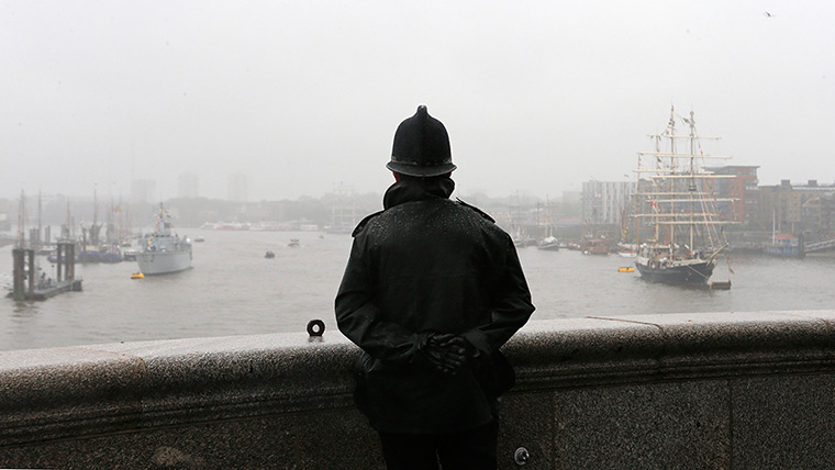 Wet UK weather 2012 : June: A policeman looks out over the River Thames 