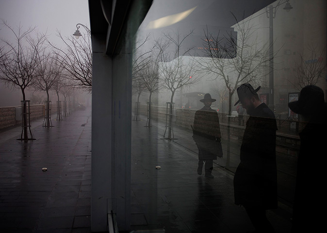 24 hours in pictures: Ultra Orthodox Jewish men stand at a train station