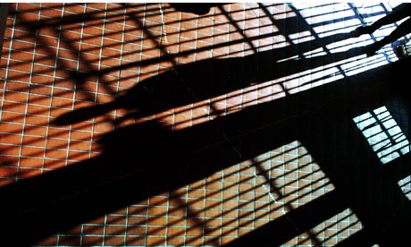 Prison bars cast shadows across the floor