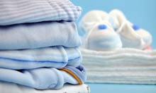 Here's some baby clothes ... can you fix my washing machine? Photograph: Andreja Donko/Alamy/Alamy Pile of blue baby clothes and slippers on cotton diapers