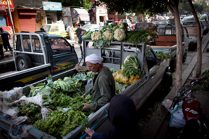 24 hours in pictures: An Egyptian street vendor sits at the back of a pickup truck