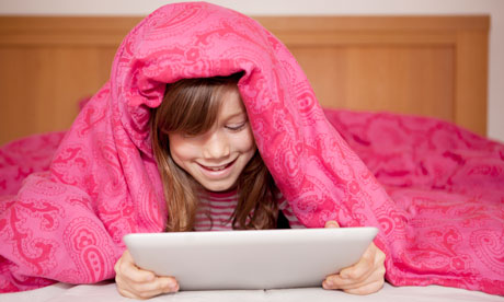 Girl playing ipad in bed