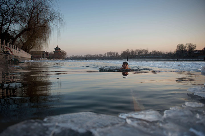 24 Hours: A man swims in the icy water of a frozen