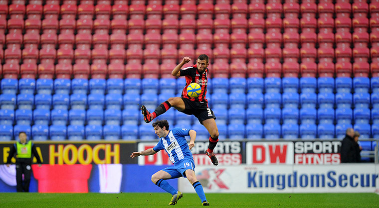 Steve Cook rises highest for the ball with Wigan's Mauro Boselli 