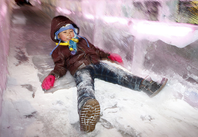 24 hours: Harbin, China: A young child slides down an ice slide