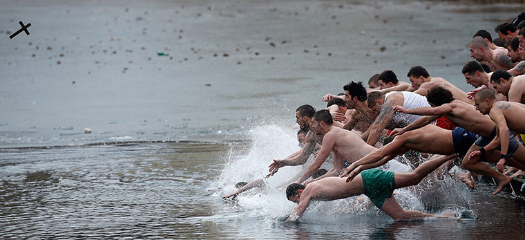 Epiphany Day: Men jump into the water to catch a wooden cross