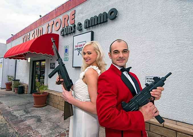 Shotgun weddings: A couple poses for a photograph with guns at The Gun Store