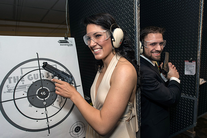 Shotgun weddings: A couple pose with guns for a photograph during a Shotgun wedding