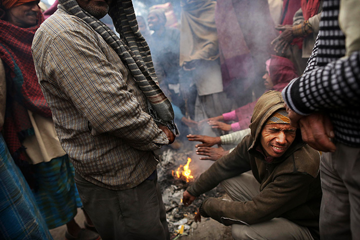 Cold weather in India: Labourers warm themselves on a fire in a market in New Delhi