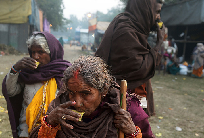 Cold weather in India: Villagers drink tea as they arrive at temporary camp in Kolkata