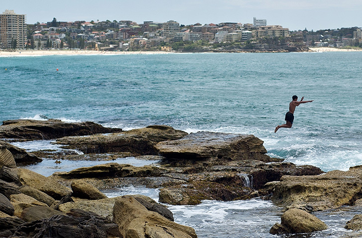 Australia heatwave: A man jumps into the sea to cool off at Manly beach in Sydney