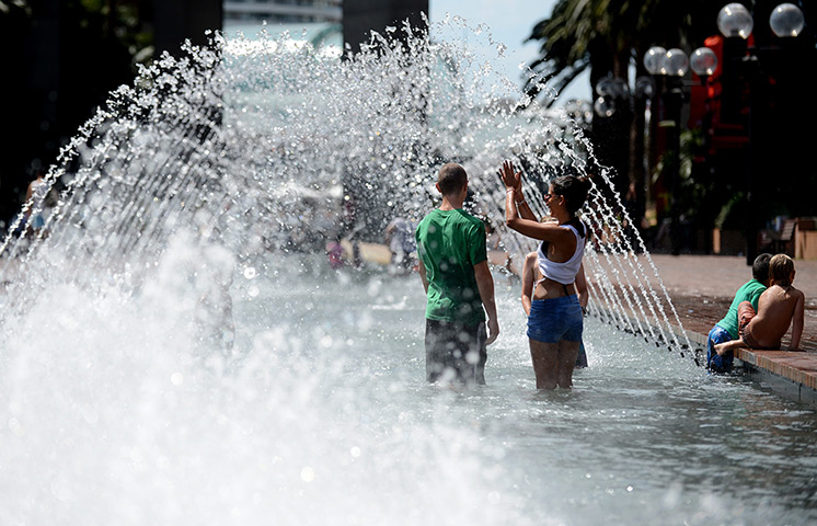 Australia heatwave: People cool off in a fountain at Darling Harbour 