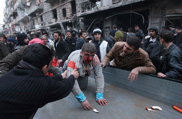 24 hours: Aleppo, Syria: People help a wounded person 