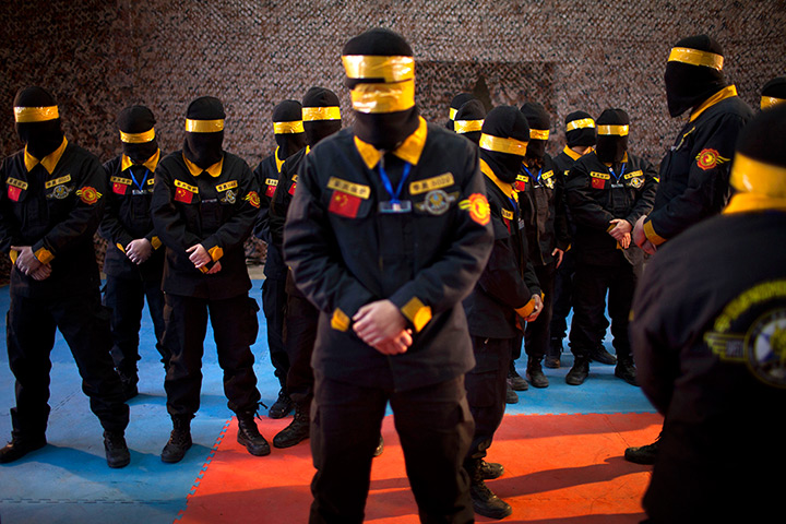 24 hours in pictures: Trainees at a body guard training camp stand with taped face masks