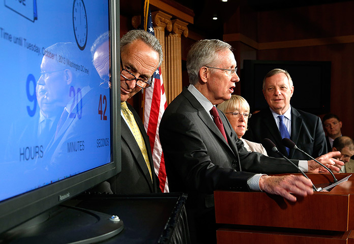 US shutdown: senators and Senate majority leader Harry Reid stand with a countdown clock