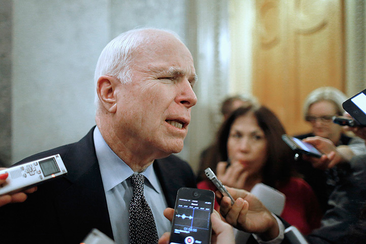 US shutdown: Senator John McCain strains to hear a reporter's question as he departs the