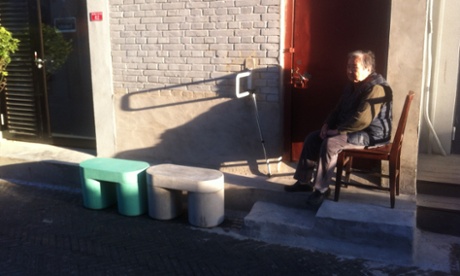 A Dashilar resident looks on at Luca Nichetto's concrete stools from the comfort of her own chair.