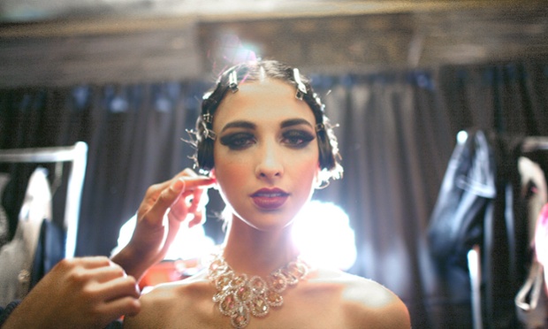 Soft lighting adds to the atmosphere of Gatsby-esque glamour as a model prepares for designer Sue Wong's spring collection show, titled Jazz Babies, during fashion week in Los Angeles, California.