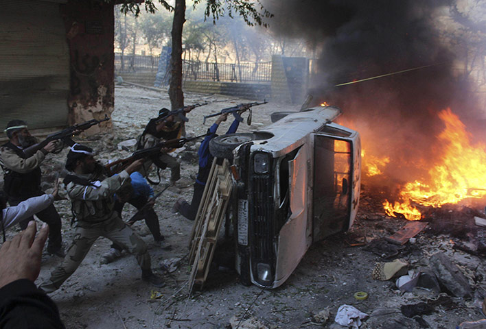 20 Photos: Free Syrian Army fighters take positions behind a damaged car in Aleppo