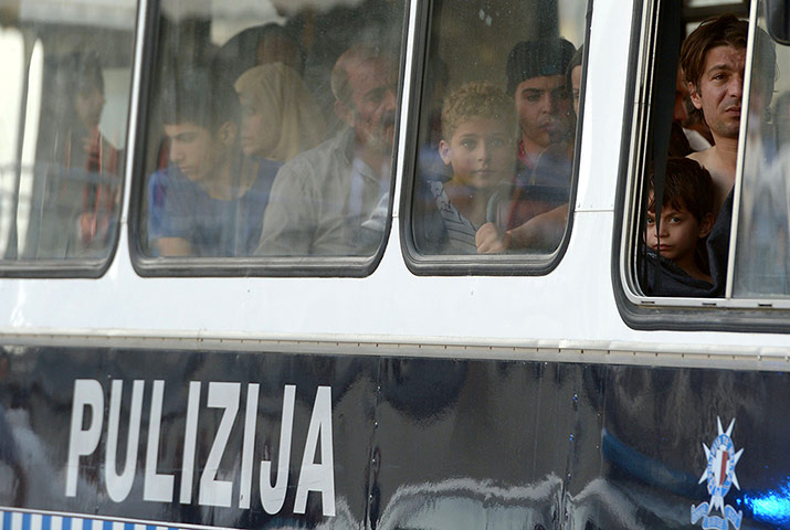 Malta: Migrants sit in a police bus 