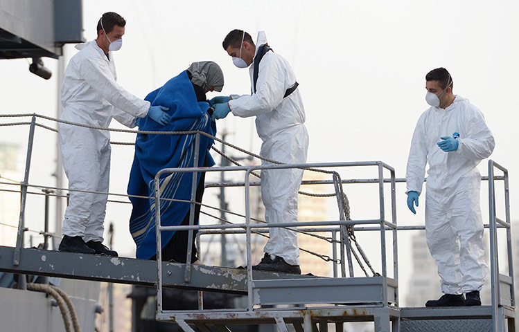 Malta: Maltese rescue workers escort a migrant who was rescued by the armed forces 