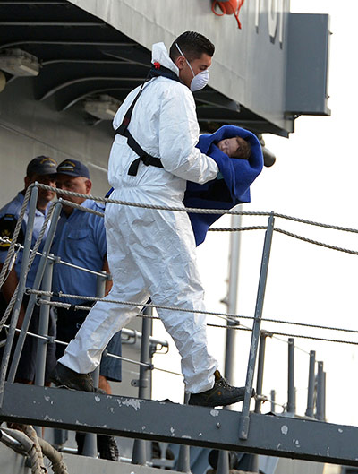 Malta: A Maltese rescue worker carries a baby r