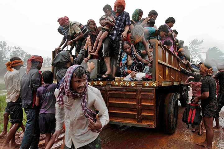 Cyclone: Indian villagers get down from a truck