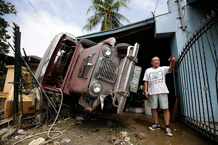 Weekend in pictures: San Miguel, Philippines: A man stands next to his jeep after flooding casued by Typhoon Nari 