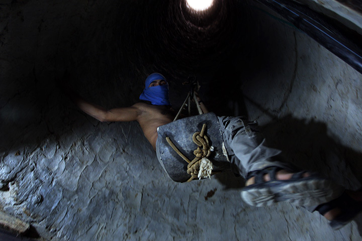 Gaza tunnels: A Palestinian tunnel-digger lowers himself into the smuggling tunnel beneat
