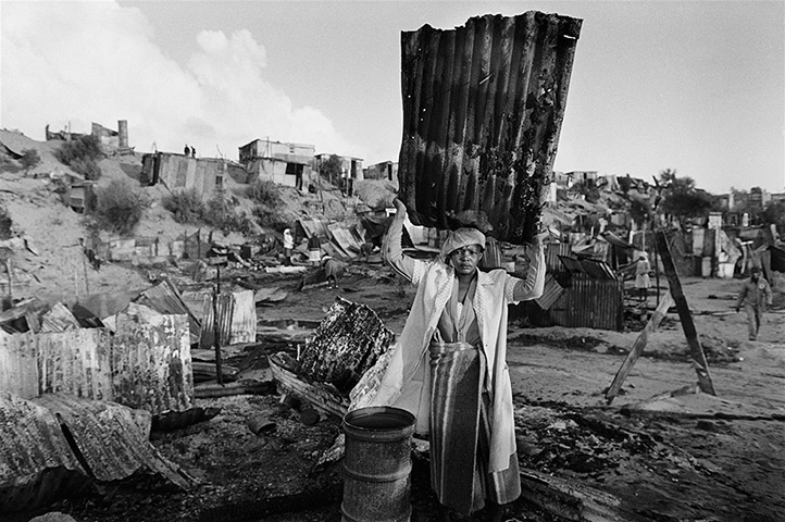 African Art Auction: Gideon Mendel, (B. South Africa, 1959)A Woman Recovers Building Materials