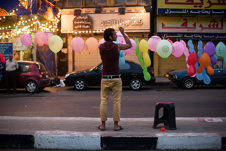 Eid al-Adha: A man puts up balloons before the early morning prayer in front of Sayyida 