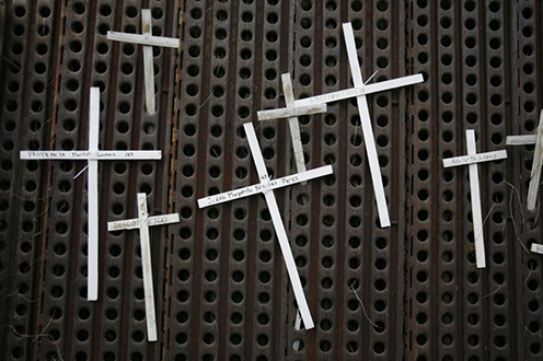 Paper crosses tied to the US-Mexico border fence representing migrants who died trying to cross the Arizona desert