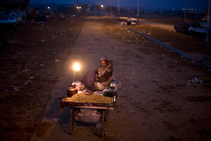 Muhammed Muheisen's Eid: Pakistani vendor, Khalid Abbasi, 48, rests on his cart after spending the n