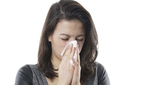 Young woman blowing her nose