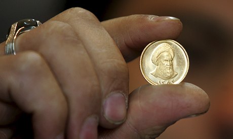 An Iranian gold trader displays a gold c