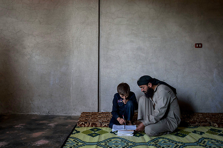 Syria schoolchildren: Ahmed al-Fikri helps his 12-year-old son Abdo al-Fikri, with his homework a