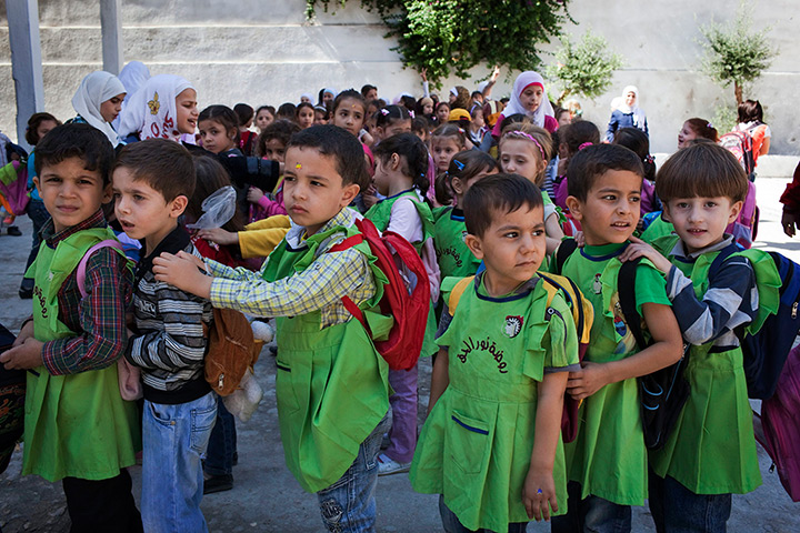 Syria schoolchildren: Children wait to enter the primary school in the Saif Al-Dawla district in 