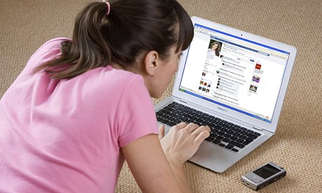 young woman looking at Facebook on laptop