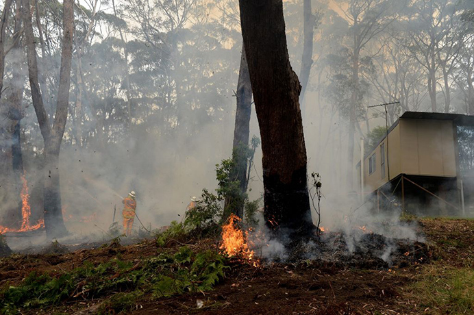 Bushfires Weds: New South Wales (NSW) Rural Fire Service crews protect a property