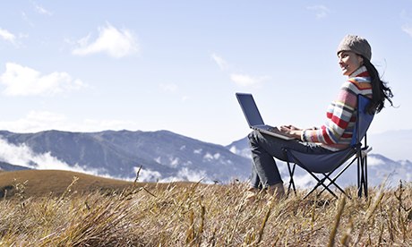 Woman on hilltop with laptop