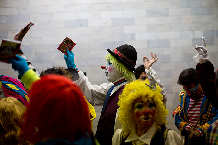 From the agencies: Clowns: Clowns raise their official clown rule book as they stand in line to regist
