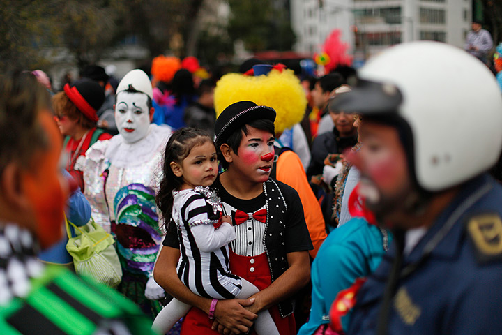 From the agencies: Clowns: A clown carrying his daughter waits for the start of a laugh-a-thon