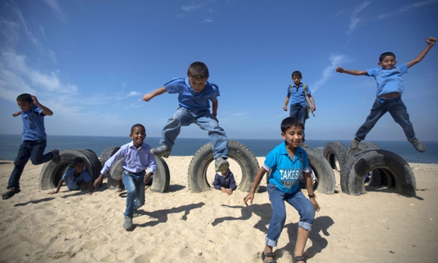 Palestinian school children play with tyres on the beach in Deir al-Balah in the central Gaza Strip.