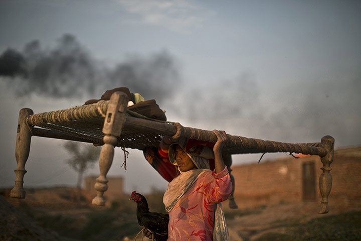 20 Photos: A Pakistani woman walks back to her home through a brick factory