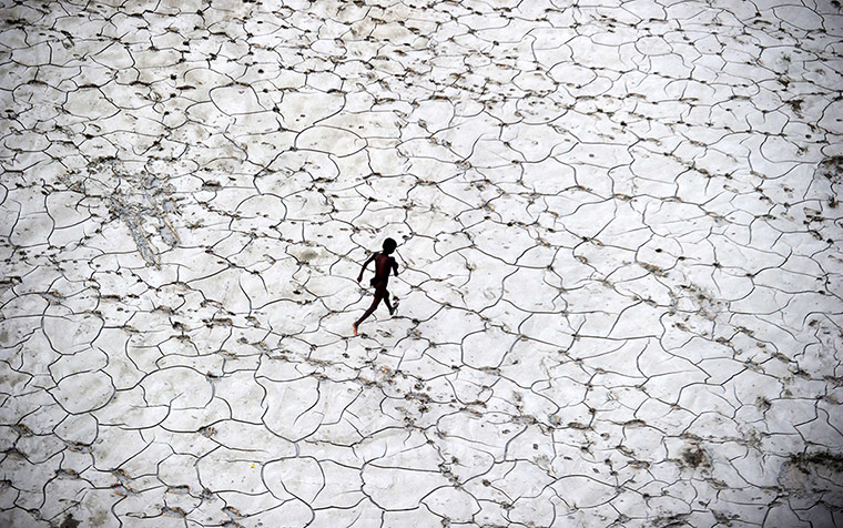 20 Photos: An Indian street child plays in a dry river bed in Allahabad