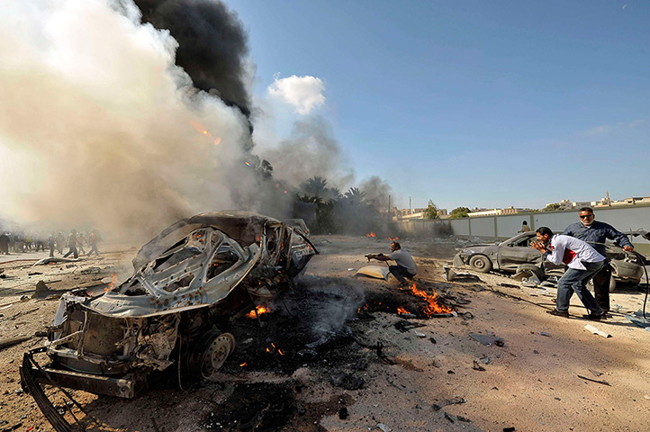 Weekend in pictures: Benghazi, Libya: Men extinguish a fire after a car bomb exploded near a school