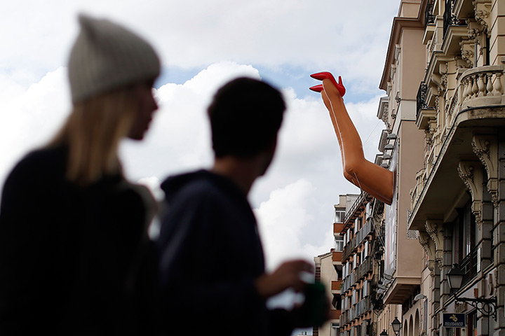 Weekend in pictures: Madrid, Spain: Madrid, Spain: A couple pass a pair of inflatable legs outside a theatre