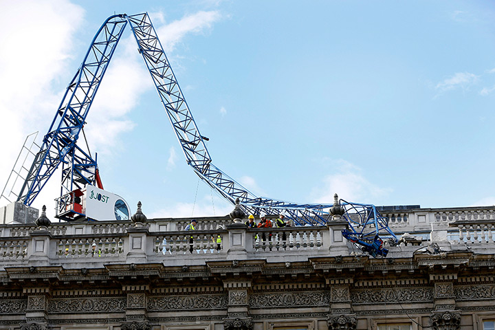 St Jude storm damage: Workmen survey the damage caused by a crane brought down by high winds onto